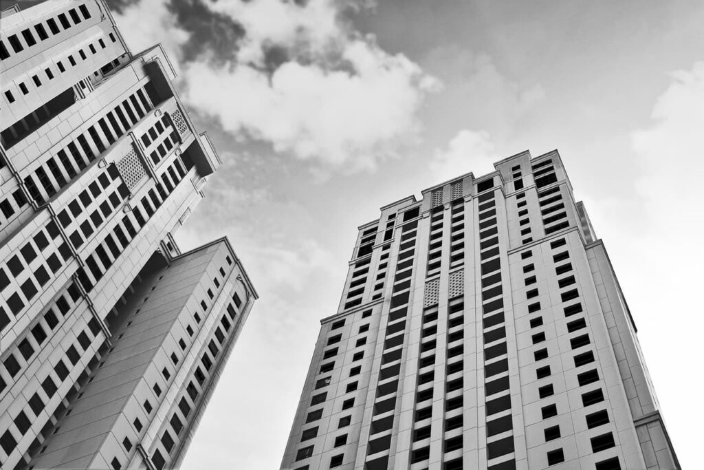 Black and white photo looking up towards the sky at a set of buildings.