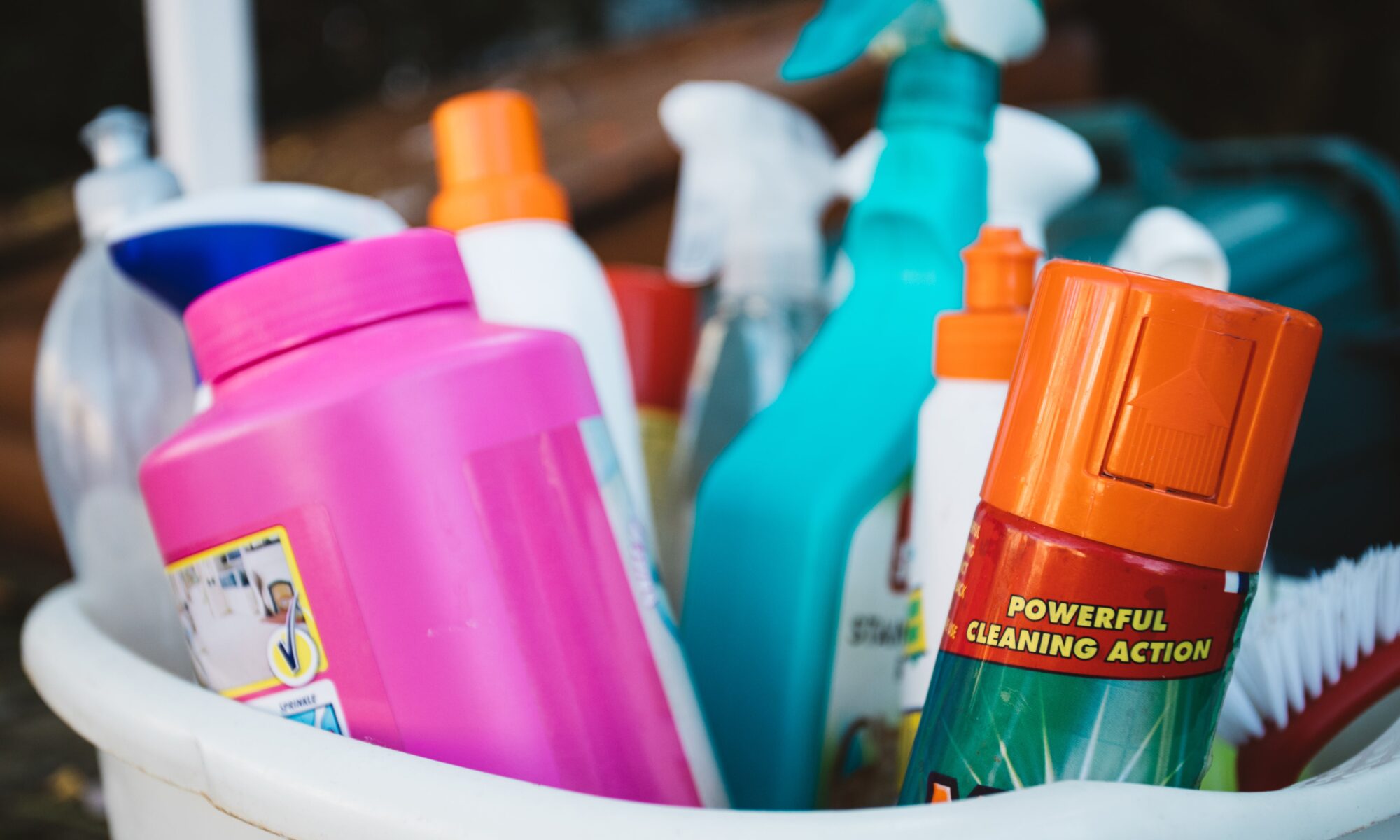 A close up of a plastic tub full of cleaning supplies